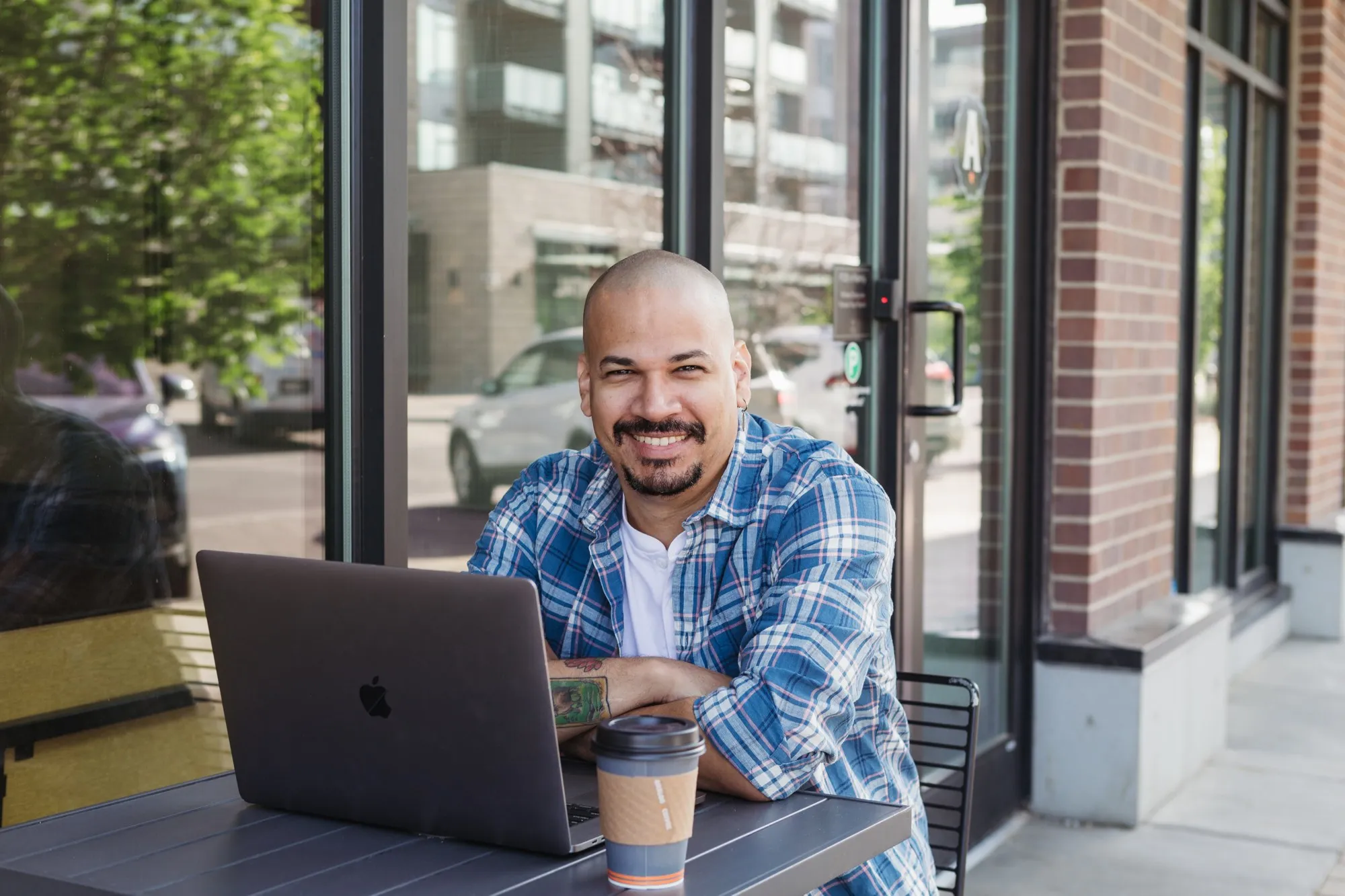 Igor Alves, founder of Chameleon Software, working on a laptop outside a café